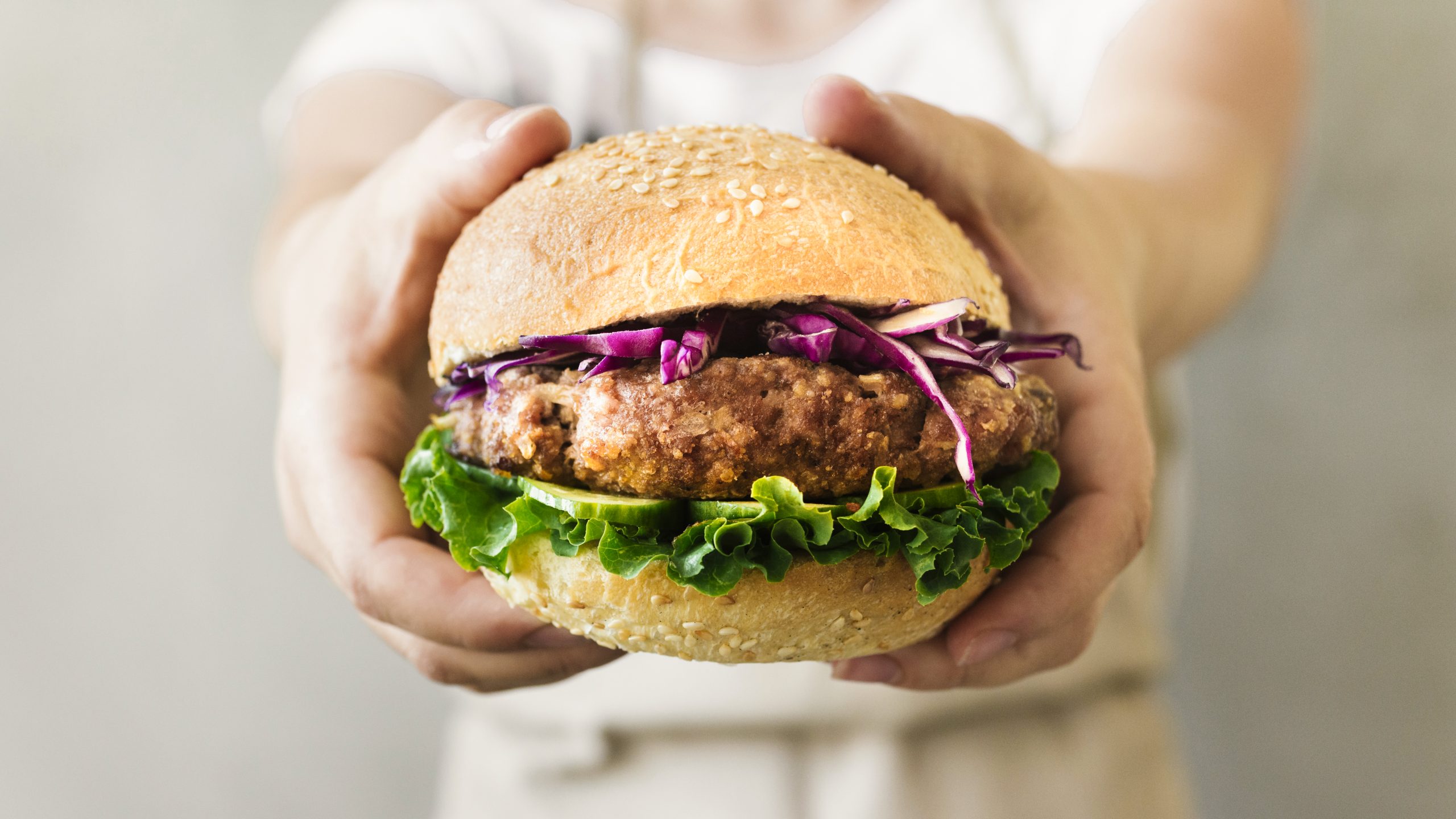 close-up-cook-holding-burger-hands